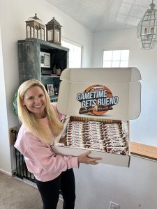 Elizabeth from SweepstakesMom holding a box of chocolate bars from a sweepstakes win, part of the real prizes our family has won.