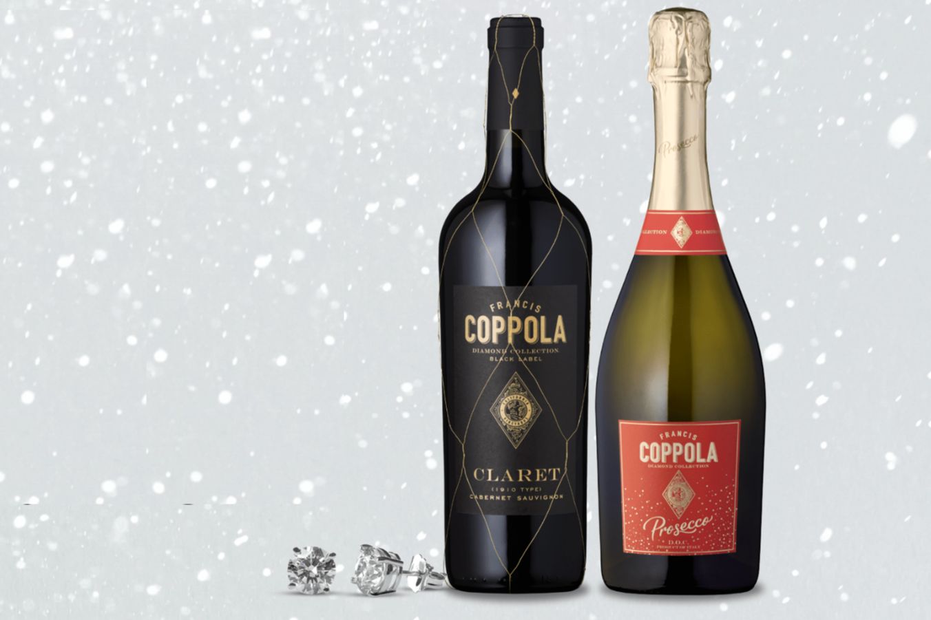 Two Francis Coppola Diamond Collection wine bottles, Claret and Prosecco, photographed on a snowy winter background with diamond stud earrings in front. Francis Coppola Diamond Collection Sip Diamond Win Diamonds Sweepstakes prize image featuring Coppola bottles and diamonds, a diamond jewelry giveaway with a $500 e-gift card prize theme. Winter-style sweepstakes photo showing Coppola Diamond Collection branding, sparkling diamonds, and a diamond win giveaway visual for the 2026 sweepstakes.