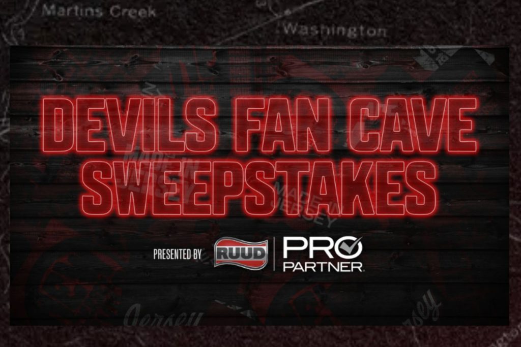 A dark, wood-textured graphic reads “Devils Fan Cave Sweepstakes” in bright red neon-style letters, with “presented by RUUD Pro Partner” below, promoting a New Jersey Devils fan cave sweepstakes for a custom Devils fan cave prize package.