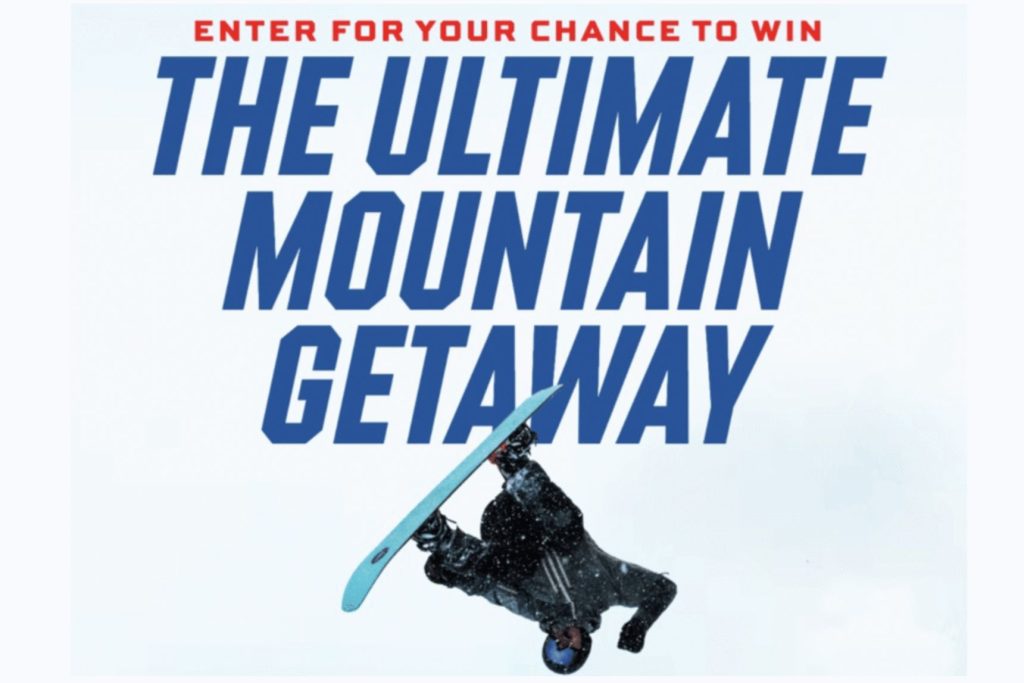 Graphic for the Deschutes Ultimate Mountain Getaway sweepstakes showing bold blue text that reads “The Ultimate Mountain Getaway” with a snowboarder mid-flip; promotional image for a mountain getaway trip prize, winter travel sweepstakes, and ski trip giveaway.