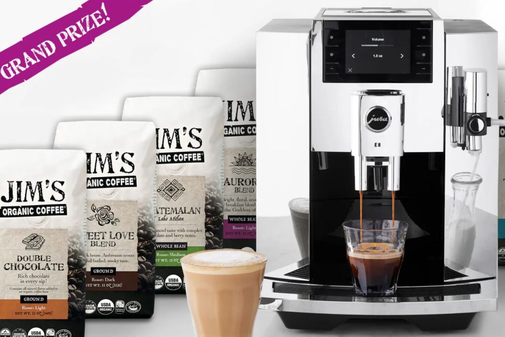 Jim’s Organic Coffee Sweepstakes prize image showing a Jura E8 fully automatic espresso machine brewing espresso next to multiple bags of Jim’s Organic Coffee and a latte drink. The photo highlights the grand prize coffee giveaway with a premium espresso machine and coffee bags, representing a Jim’s Organic Coffee sweepstakes contest with free coffee and coffee maker prizes.