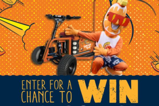 A Shock Top branded Kooler Kartz electric ride-on cooler displayed against a bright orange background, featuring a four-wheel motorized cooler designed for off-road riding and go-kart style fun. The image shows the electric cooler cart with large tires and handlebars, highlighting the grand prize in the Shock Top Kooler Kartz Sweepstakes. This promotional image showcases the $6,500 electric ride-on cooler prize that doubles as a powered go-kart.