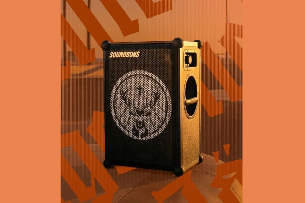 A black and gold Soundboks-style party speaker with the Jägermeister stag logo on the front, shown on an orange background, featuring a branded Jägermeister speaker giveaway prize; this image highlights the large portable speaker prize, a Jägermeister Soundboks party speaker, and a high-value branded speaker sweepstakes.