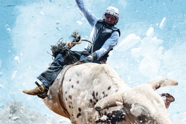 Action photo of a professional bull rider mid-ride on a powerful bull with ice-like shards flying through a blue background, matching the rugged vibe of a Busch Light PBR Sweepstakes flyaway prize. The image shows a high-energy bull riding moment that fits a PBR World Finals trip giveaway, highlighting the rodeo-style action tied to the Busch Light PBR Sweepstakes. Dynamic bull riding scene used to represent a PBR flyaway sweepstakes prize featuring VIP event passes and a trip for two.