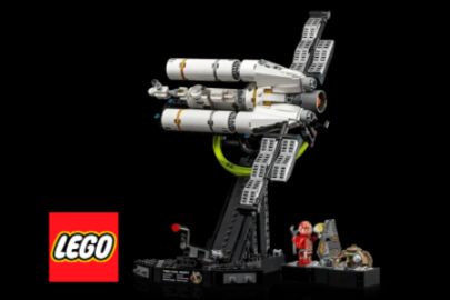 A detailed LEGO space shuttle model stands prominently, showcasing its sleek design and features, accompanied by mini-figures and a display base against a black background, featured in the IMAX Project Hail Mary LEGO Sweepstakes