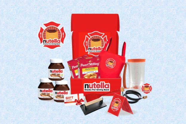 A red box is filled with baking essentials, including jars of chocolate spread, a gift card, and colorful utensils, all set against a light blue background, highlighting a sweet cooking theme, featured in the Nutella Stacks For Giving Back Sweepstakes