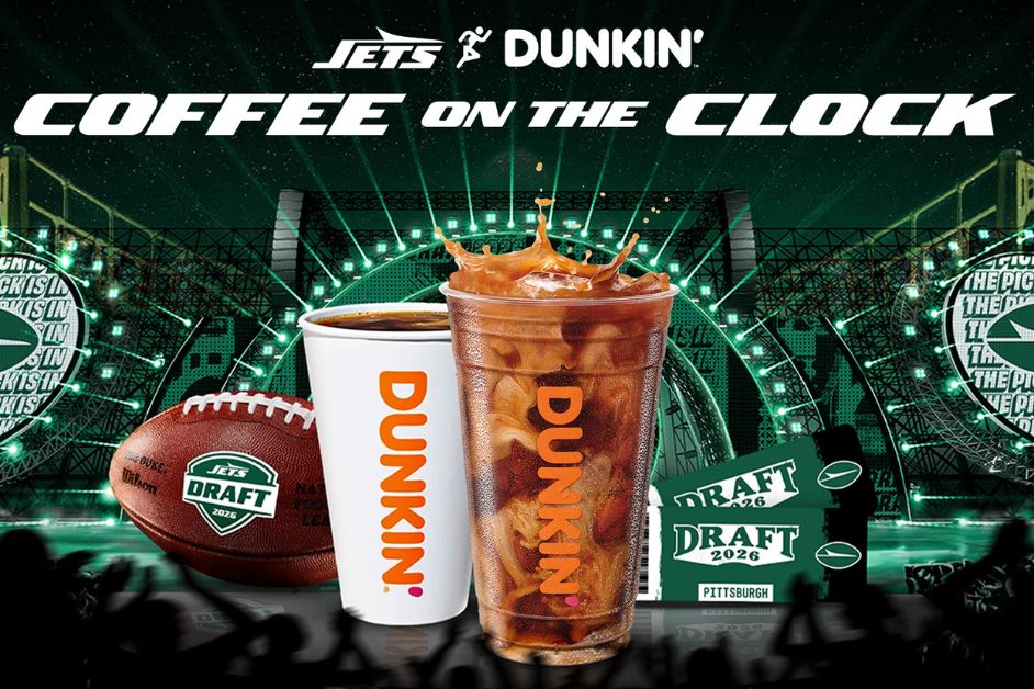A backdrop of a football stadium features two Dunkin' coffee cups, one iced with splashes, and a football, promoting the Jets' draft event, featured in the New York Jets Trip to Draft Sweepstakes