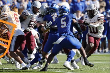 A football player in a blue uniform is about to be tackled amidst a group of opposing players in white. The scene captures the intensity of a game day, featured in the NCAA FCS Championship Tickets Sweepstakes