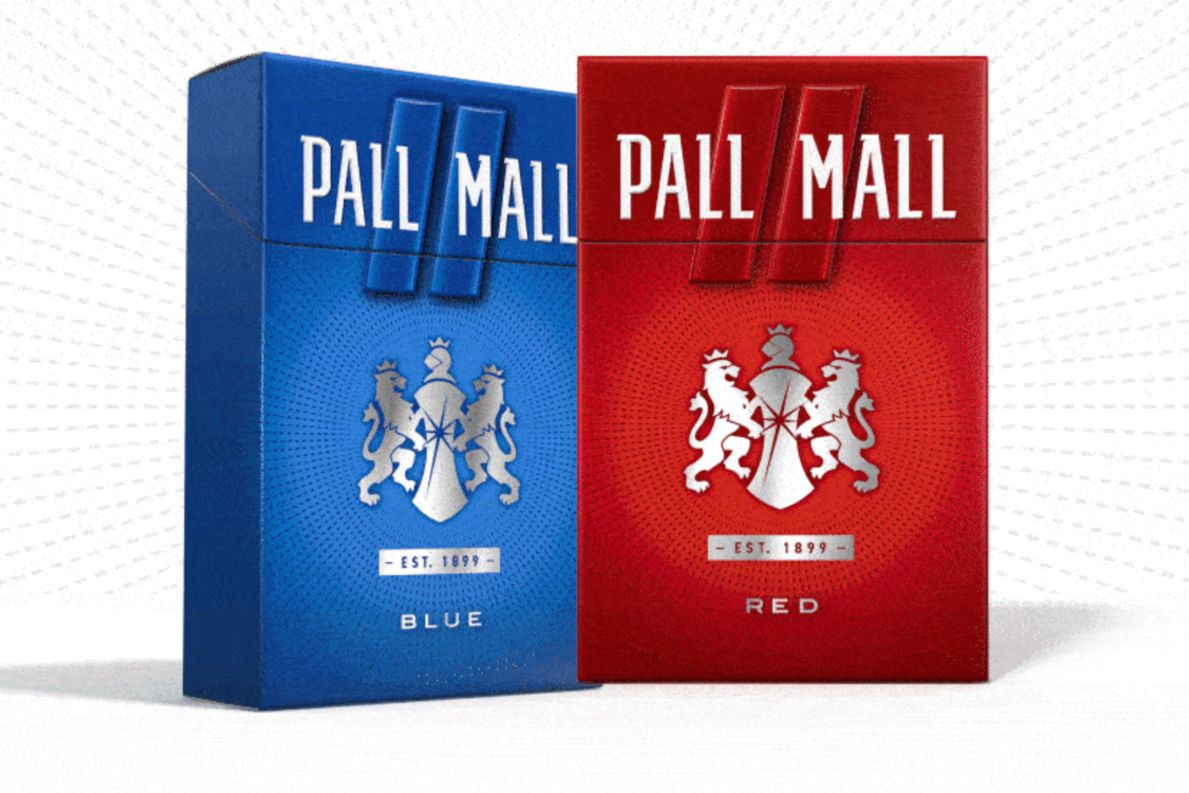 Two cigarette packs stand side by side: one blue labeled "BLUE" and the other red labeled "RED," both featuring a silver emblem with lions and a shield design, featured in the Pall Mall $10,000 Sweepstakes