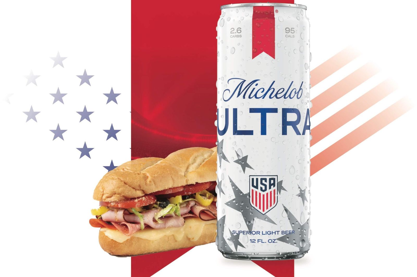 A cold can of beer sits beside a hearty sub sandwich, featuring layers of meats, cheese, and fresh vegetables, against a backdrop of red, white, and blue graphics, featured in the Michelob Ultra Hot Foods Sweepstakes