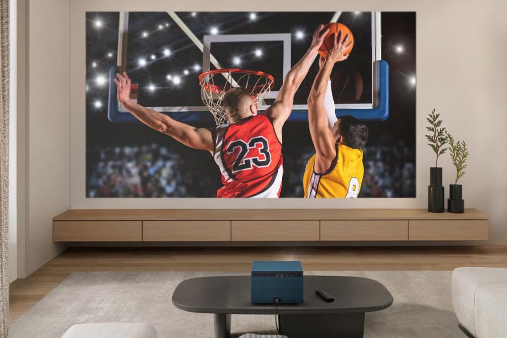 A basketball player in a red jersey attempts to block a shot from another player in a yellow jersey near the hoop, with a dynamic crowd and bright arena lights in the background, featured in the ViewSonic LX60HD Sweepstakes
