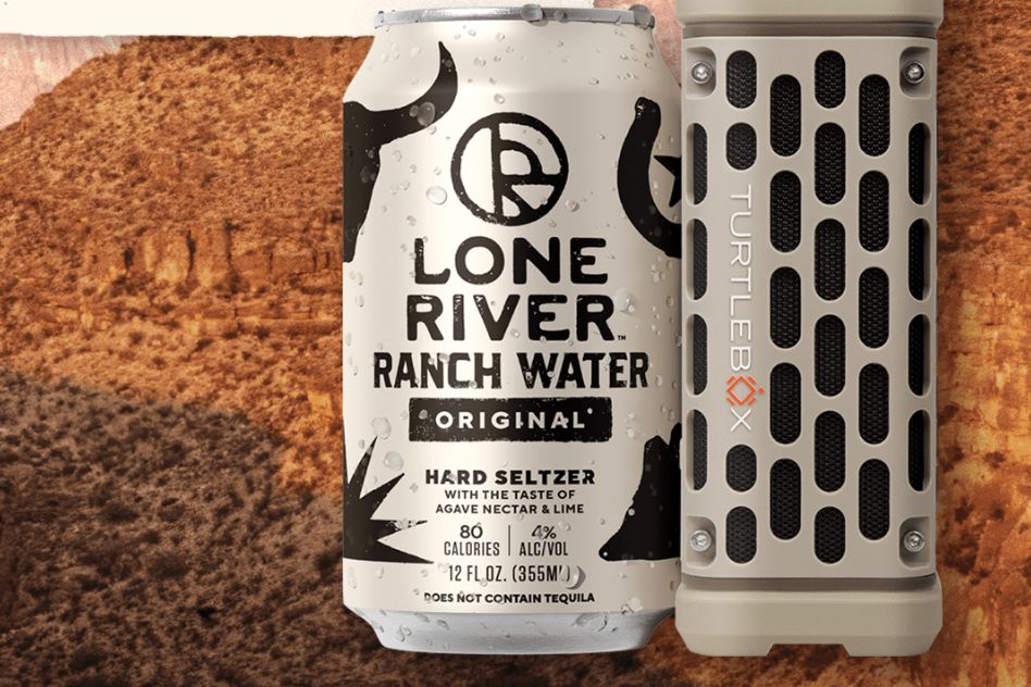 A can of hard seltzer accompanied by a portable speaker is set against a textured, earthy background, suggesting a vibrant outdoor gathering or adventure atmosphere, featured in the Lone River Turtlebox Speaker Sweepstakes