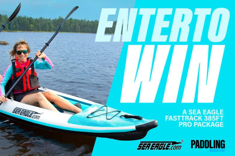 A smiling woman in a kayak paddles on a lake, wearing a life vest and colorful athletic wear, with trees and water in the background, featured in the Sea Eagle FastTrack 385ft Pro Package Sweepstakes