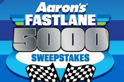 A vibrant graphic features a racing theme with checkered flags and bold text promoting a sweepstakes, emphasizing speed and competition, featured in the Aaron's $5,000 Sweepstakes