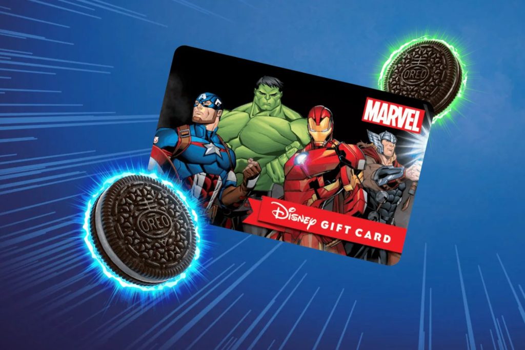 A colorful gift card featuring Marvel superheroes is displayed against a dynamic blue background, with an Oreo cookie floating beside it, enhanced by visual effects, featured in the OREO $1,000 Shopping Spree Sweepstakes