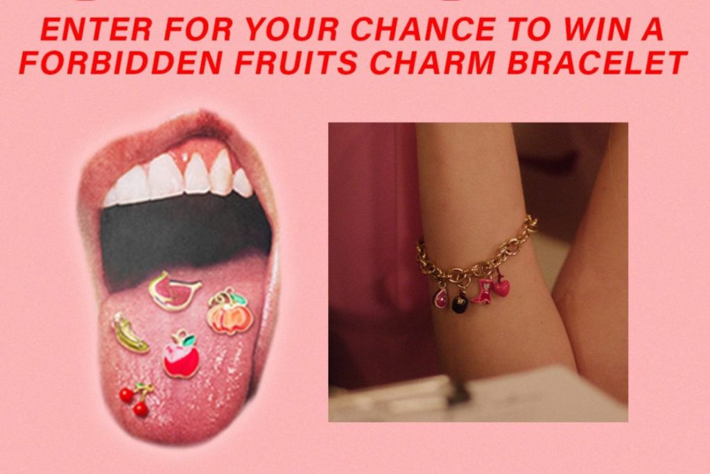 A mouth is open wide, displaying colorful fruit-shaped charms on a tongue. Beside it, a hand shows off a charm bracelet adorned with playful fruit and other decorative items, featured in the Regal Crown Club Forbidden Fruit Charm Bracelet Sweepstakes