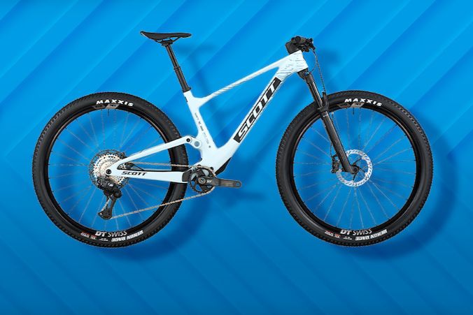 A sleek white mountain bike is displayed against a vibrant blue background, showcasing its modern design and sturdy wheels, ideal for outdoor adventures and rugged terrains, featured in the Pinkbike Scott Spark Pro Sweepstakes