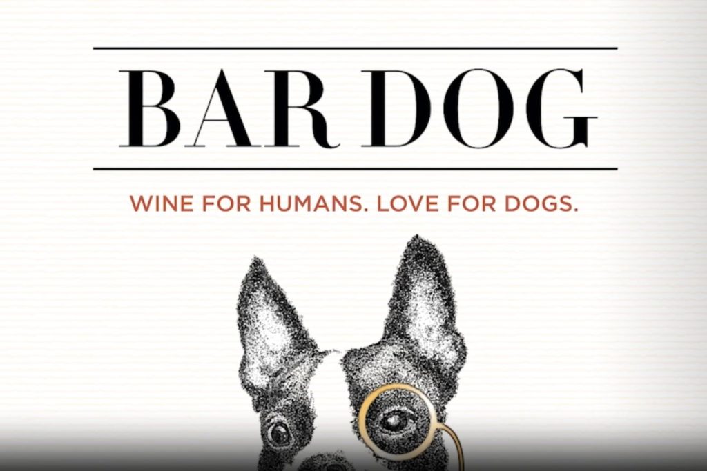 A whimsical illustration of a dog wearing round glasses, accompanied by the text "Wine for Humans. Love for Dogs," highlighting a playful connection between pets and wine, featured in the Bar Dog Label Sweepstakes
