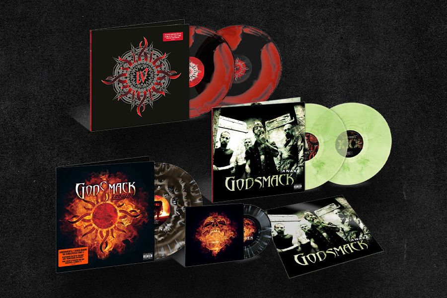 A collection of vinyl records arranged on a dark background, featuring various albums by a rock band, including multiple colored discs and album covers showcasing band imagery and designs, featured in the uDiscover Music Godsmack Vinyl Sweepstakes