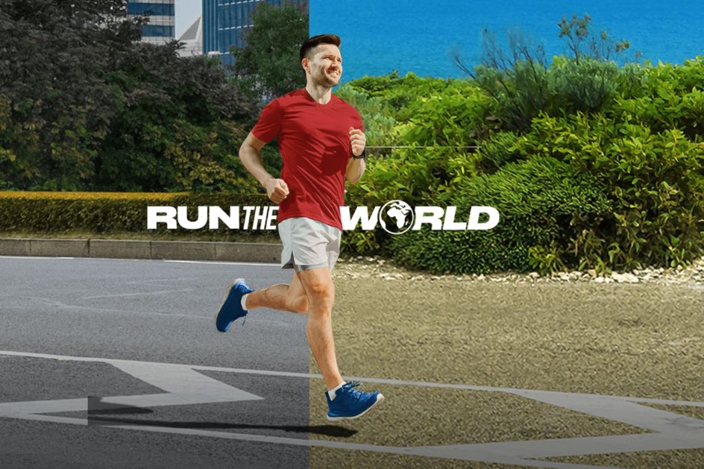 A man in a red shirt and shorts jogs along a path, smiling as he enjoys his run amidst greenery and blue skies, embodying an active lifestyle, featured in the CLIF Run the World Sweepstakes