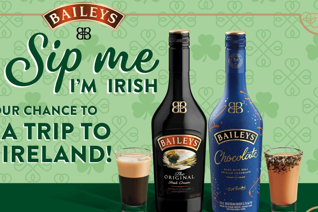 A delightful scene showcasing two bottles of Baileys, one classic and one chocolate-flavored, alongside delicious layered drinks, set against a festive green background with shamrocks, featured in the Baileys Ireland Sweepstakes