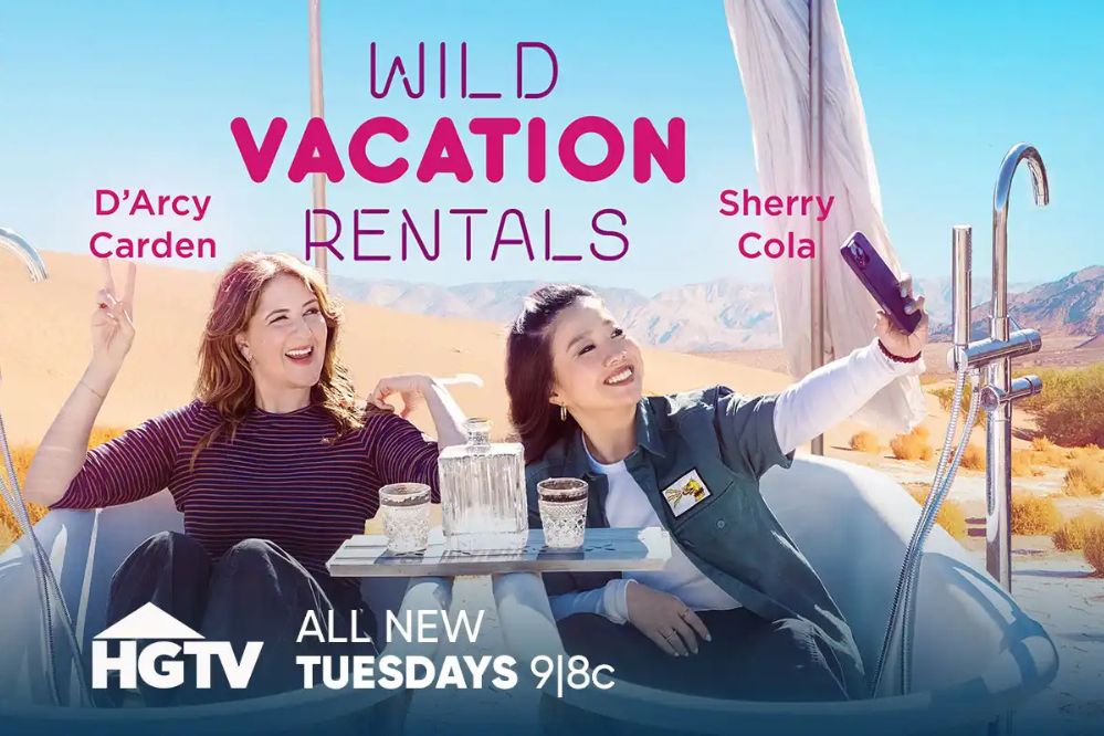 Two women relax in a bathtub set against a desert backdrop, one taking a selfie while the other sits casually, enjoying drinks. The scene captures a fun vacation vibe, featured in the Valpak $10,000 HGTV Sweepstakes