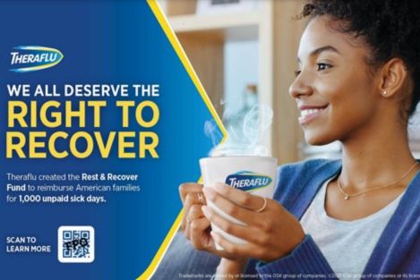 A woman smiles while holding a steaming mug, embodying comfort and wellness. The background hints at a cozy indoor setting, emphasizing a moment of relaxation, featured in the Theraflu $200 Sweepstakes