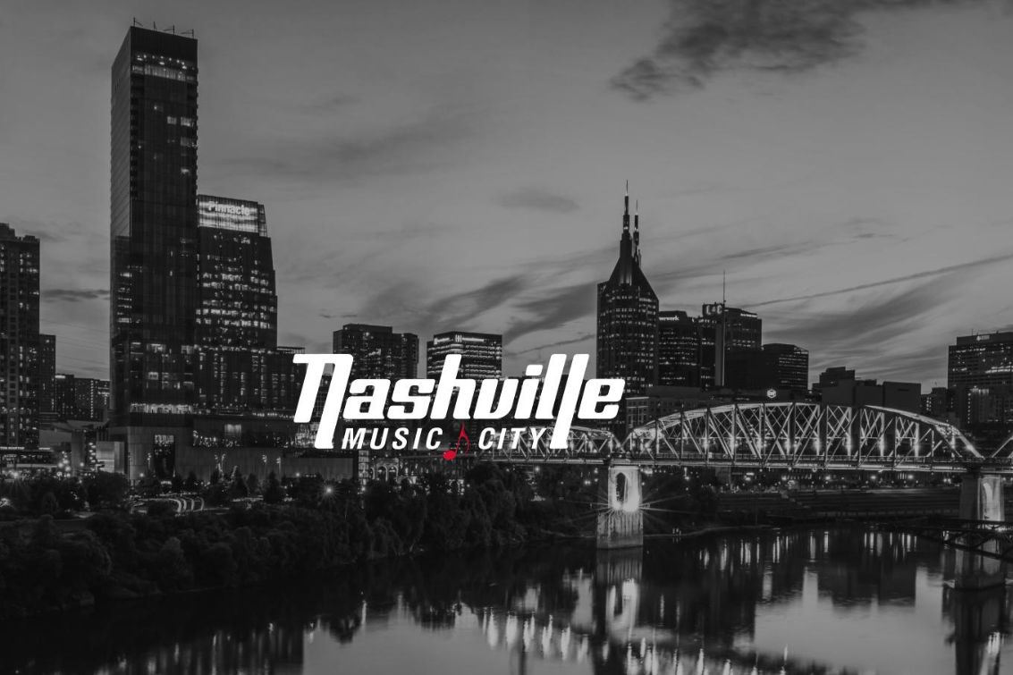 A panoramic view of Nashville's skyline at dusk, showcasing tall buildings and a bridge over a river, with a dramatic sky enhancing the city's vibrant atmosphere, featured in the Nashville in Spring Bloom Giveaway