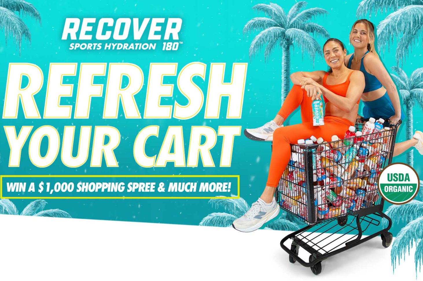 Two women are playfully posing on a shopping cart filled with colorful sports drinks, set against a tropical background with palm trees. They exude energy and fun, featured in the RECOVER 180 Gift Card Sweepstakes