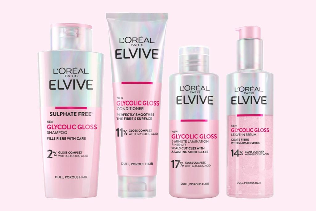 Four L’Oreal Paris Elvive Glycolic Gloss hair products on a soft pink background, showing shampoo, conditioner, a 5-minute lamination rinse, and a leave-in serum. L’Oreal Elvive Glycolic Gloss giveaway image featuring a glossy haircare set and beauty prize pack style visuals. L’Oreal Paris Elvive Glycolic Gloss product lineup photo used for a beauty sweepstakes featuring hair shine and smoothness products.