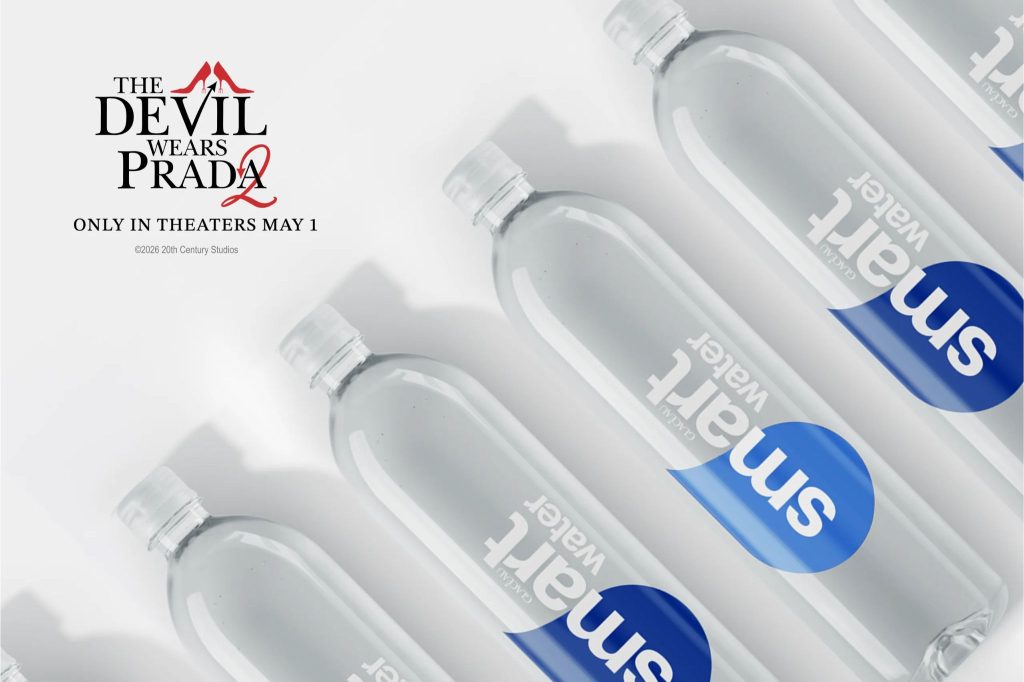 Several clear bottles of water are arranged in a row, with visible branding. A promotional tagline for a movie is displayed in the upper left corner. The background is white, featured in the smartwater Cerulean Sweepstakes