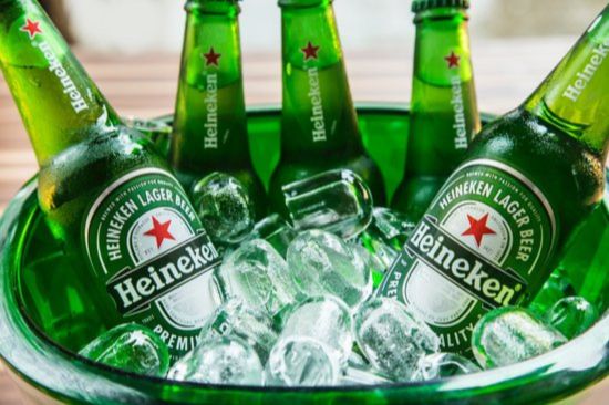 A bowl filled with ice showcases several green bottles of lager. The chilled bottles, perfectly arranged, glisten with condensation, creating a refreshing summertime vibe, featured in the Heineken Soccer Tickets Sweepstakes