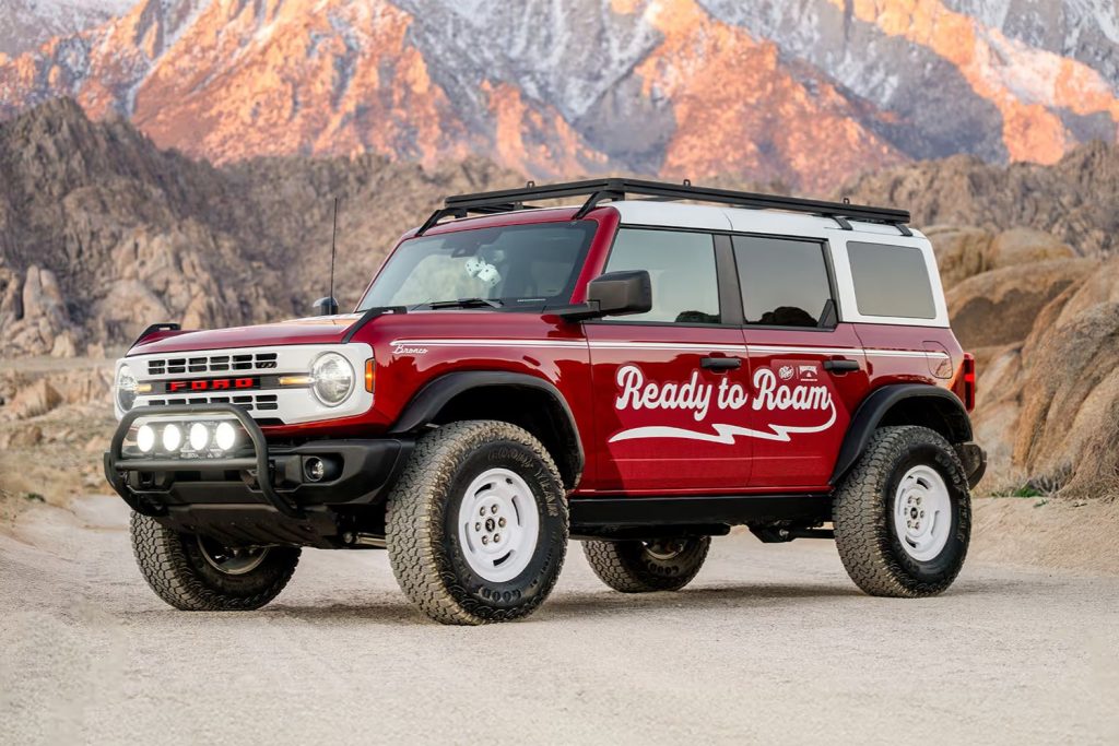 A red off-road SUV parked on a dirt path with rugged mountains in the background. The vehicle displays a slogan suggesting adventure and exploration, featured in the Ready to Roam Sweepstakes