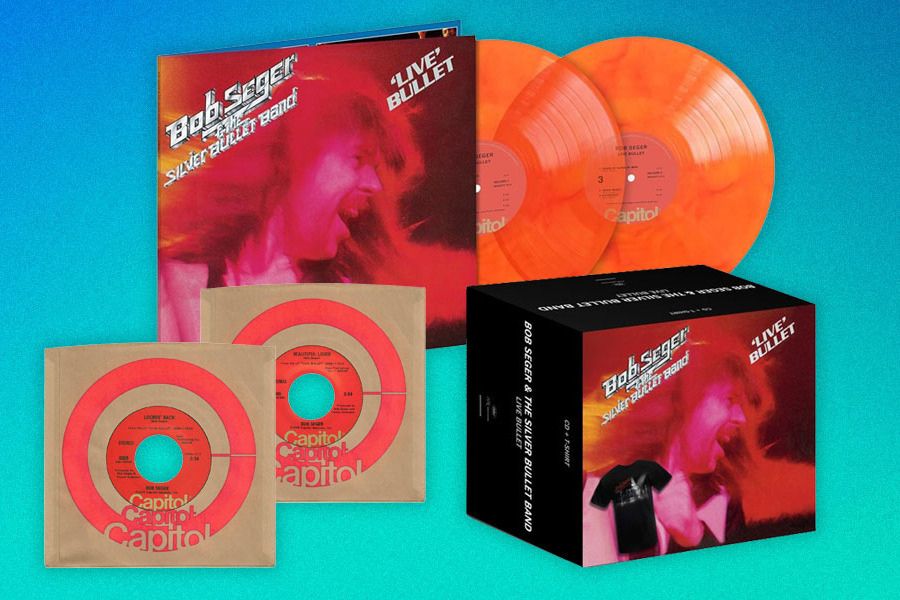 A vibrant display featuring Bob Seger & The Silver Bullet Band's "Live Bullet" album, alongside orange vinyl records and classic 45s, set against a blue gradient background, featured in the uDiscover Bob Seger Live Bullet Sweepstakes