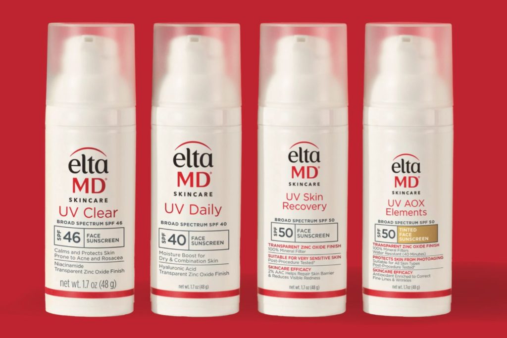 Four bottles of facial sunscreen are displayed against a vibrant red background, showcasing different formulations and SPF levels for skincare protection, featured in the CP Skin Health Dermatology Consult Sweepstakes