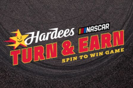 A textured road surface is prominently displayed, featuring colorful graphics for a promotional NASCAR game called "Turn & Earn," inviting players to spin for prizes, featured in the Hardee's Victory Lap Sweepstakes