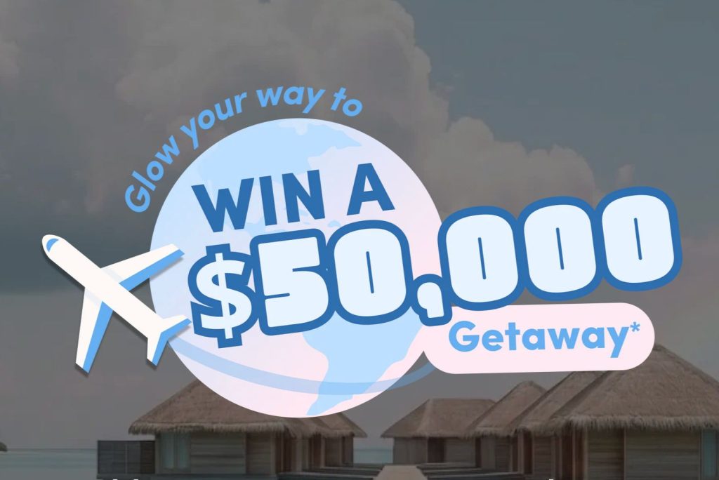 A serene tropical scene features thatch-roofed huts along a calm shoreline, with clouds overhead. Text promotes a $50,000 getaway contest with a plane icon, featured in the The Collagen Co $50k Sweepstakes