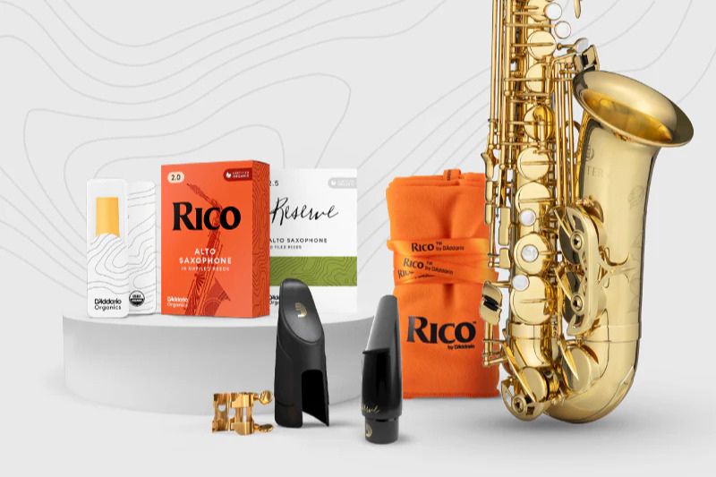 A polished gold saxophone rests among accessories including reeds and mouthpieces, creating a vibrant display for musicians and music enthusiasts, featured in the Jupiter Saxophone Giveaway