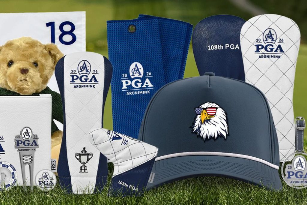 A collection of golf-themed merchandise featuring a bear plush, hats, towels, and club headcovers, all displayed on a grassy background with a golf flag in view, featured in the PGA Championship Accessories Sweepstakes