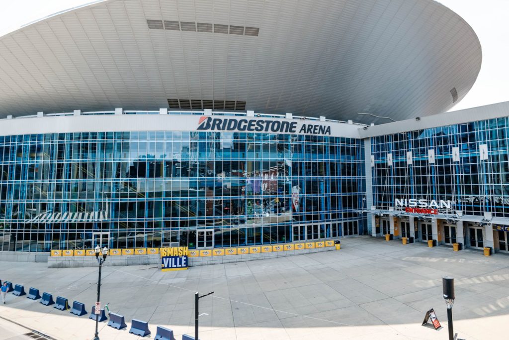 The exterior of Bridgestone Arena features large glass windows and a sweeping roof. A "SMASHVILLE" banner and empty plaza indicate a quiet venue, typical of non-event days, featured in the Music City Rodeo Giveaway
