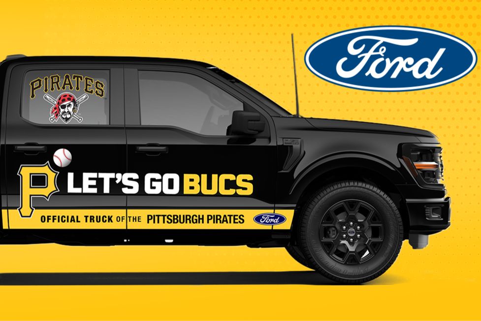 A black pickup truck features bold yellow graphics supporting the Pittsburgh Pirates, including a pirate mascot and "LET'S GO BUCS" slogan, set against a bright yellow background, featured in the Pittsburgh Pirates F-150 Sweepstakes