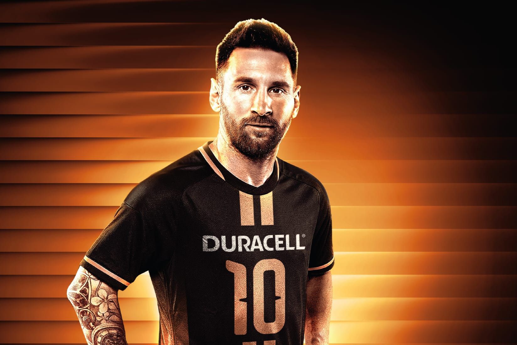 A man stands confidently in a black sports jersey with an orange background, showcasing his tattoos and distinctively styled hair, embodying an athletic and determined presence, featured in the Duracell Messi Jersey Sweepstakes