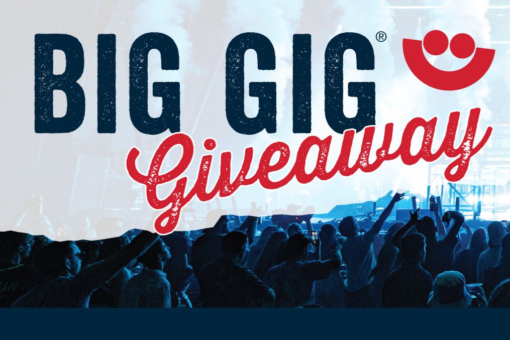 A lively crowd enjoys a concert, with hands raised in excitement. Bright stage lights and smoke create an energetic atmosphere, drawing everyone into the moment, featured in the Cousins Subs VIP Sweepstakes