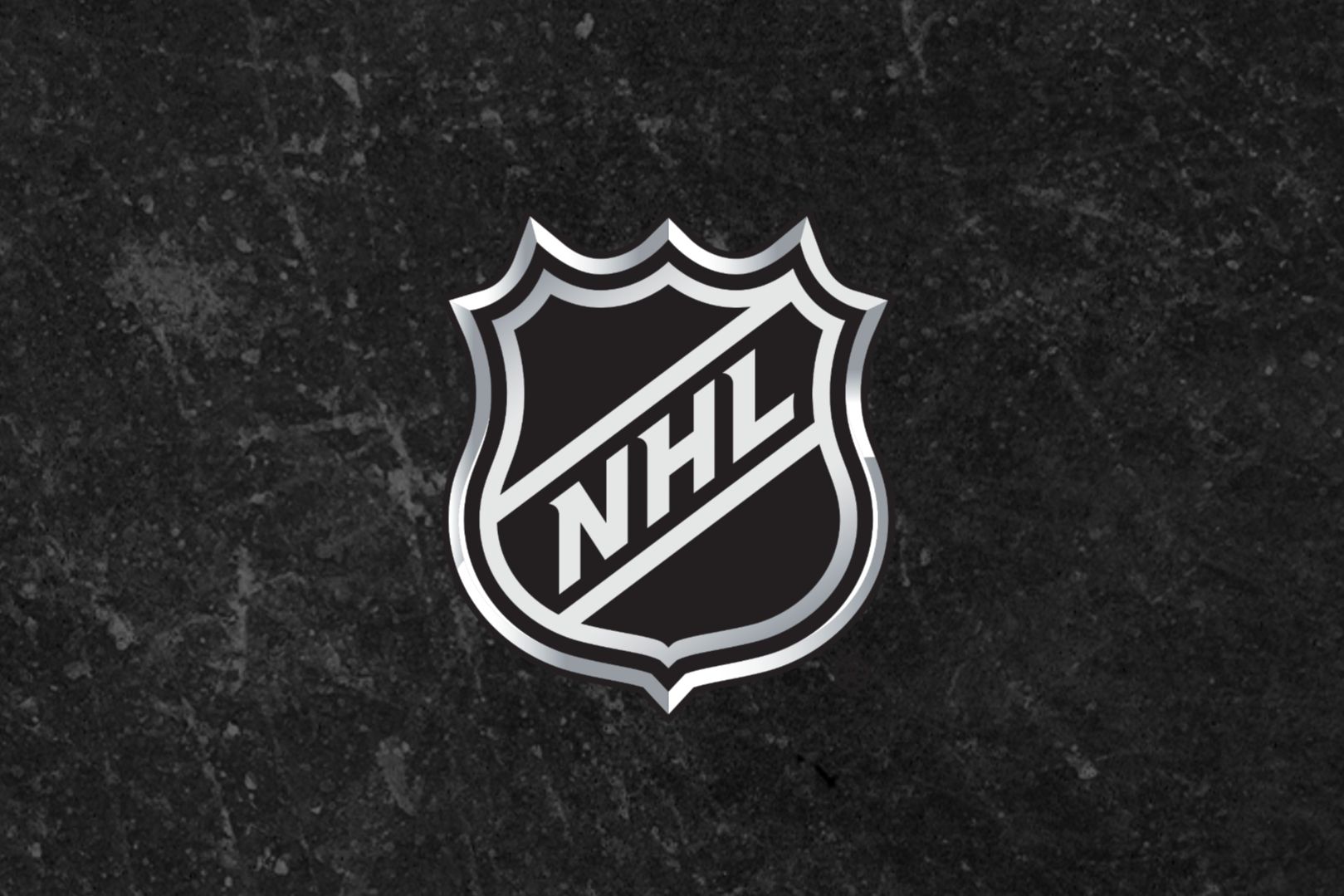 A silver NHL shield logo stands out against a textured black background, highlighting the iconic shape and lettering associated with professional ice hockey, featured in the NHL Stanley Cup Playoffs Sweepstakes