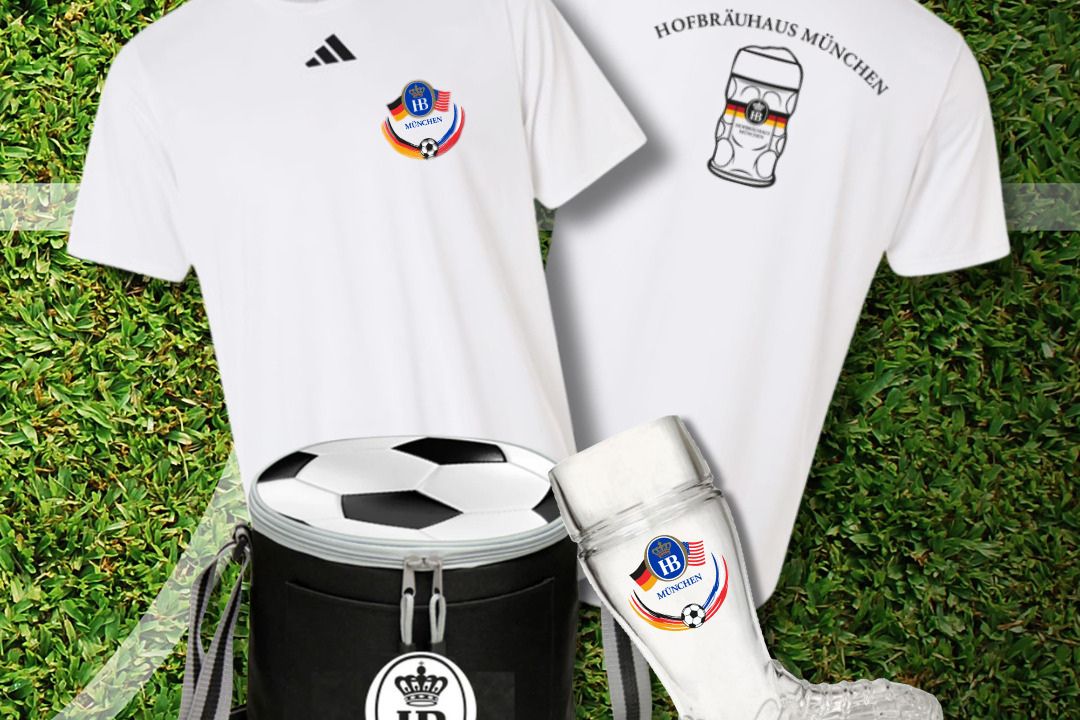 A soccer-themed display featuring a white t-shirt with a logo, a black cooler topped with a soccer ball, and a glass boot, all set against a grassy background, featured in the Hofbräu Soccer Sweepstakes