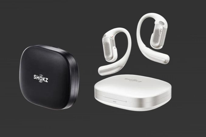 Wireless earphones in white and a black charging case are displayed against a dark background, showcasing their modern design and sleek features, featured in the Shokz OpenFit Pro Sweepstakes