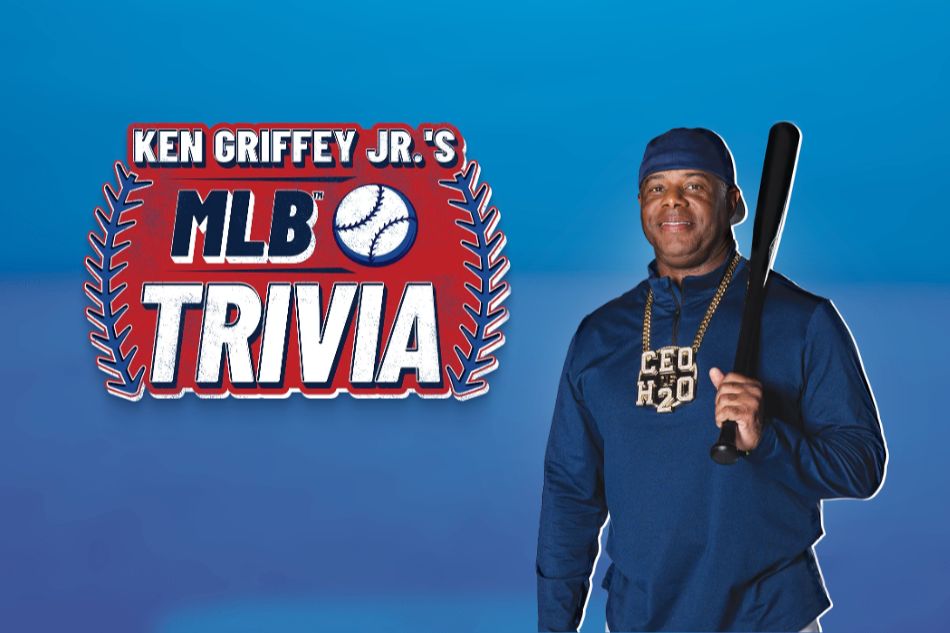 A man in a blue sweatshirt holds a baseball bat, smiling confidently against a blue background. The image features trivia related to MLB, with a playful and engaging vibe, featured in the Ken Griffey Jr. MLB Trivia Sweepstakes