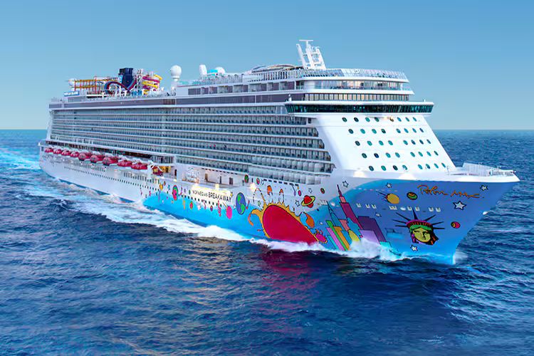 A colorful cruise ship sails through calm blue waters, showcasing vibrant artwork on its exterior. The sunny sky enhances the cheerful atmosphere surrounding the vessel, featured in the AAdvantage Cruises Million Miles Giveaway