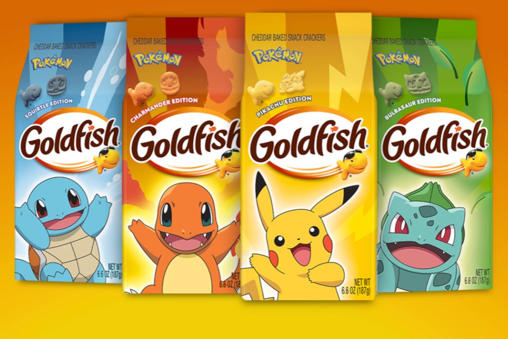 Colorful packages of Goldfish crackers featuring Pokémon characters, including Squirtle, Charmander, Pikachu, and Bulbasaur, arranged against a bright orange background, featured in the Campbells Pokemon Sweepstakes