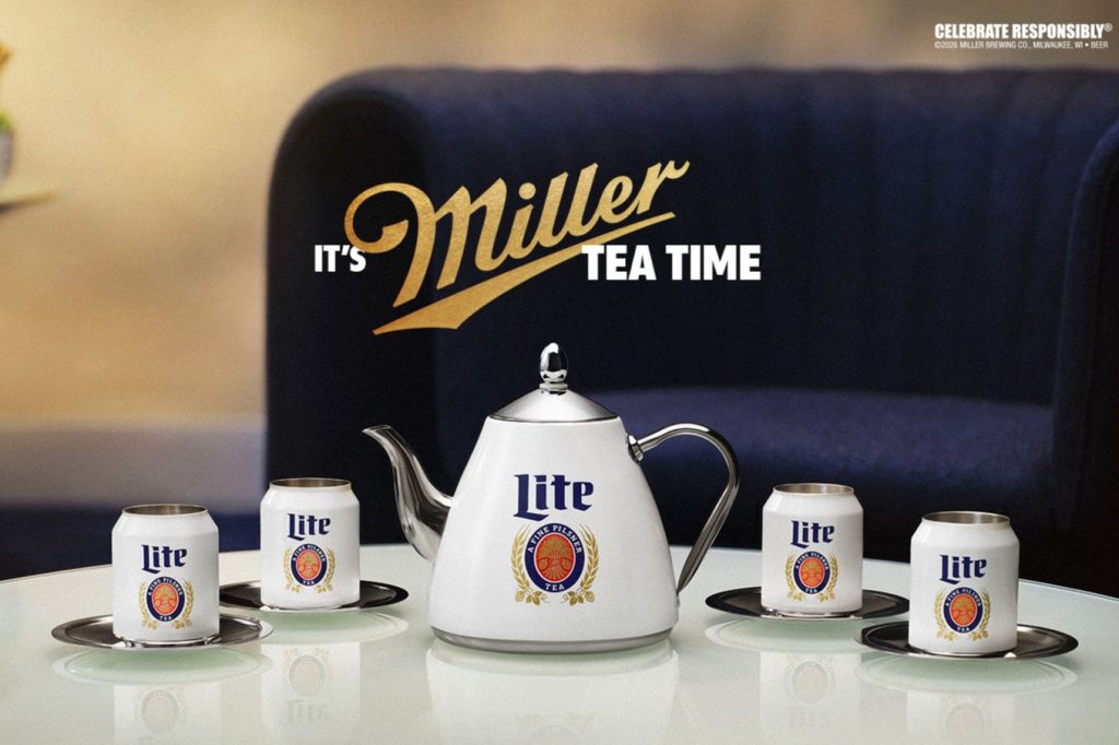 A sleek white teapot sits at the center of a table, surrounded by cans on silver plates. The setting features a deep blue couch in the background, suggesting a cozy atmosphere, featured in the Miller Lite Tea Time Sweepstakes